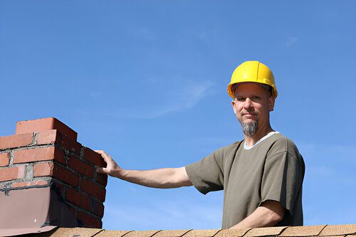 Man met bouwhelm op dak